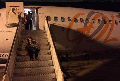 Katya Hemelrjik da Silva crawl stairs to board Gol plane